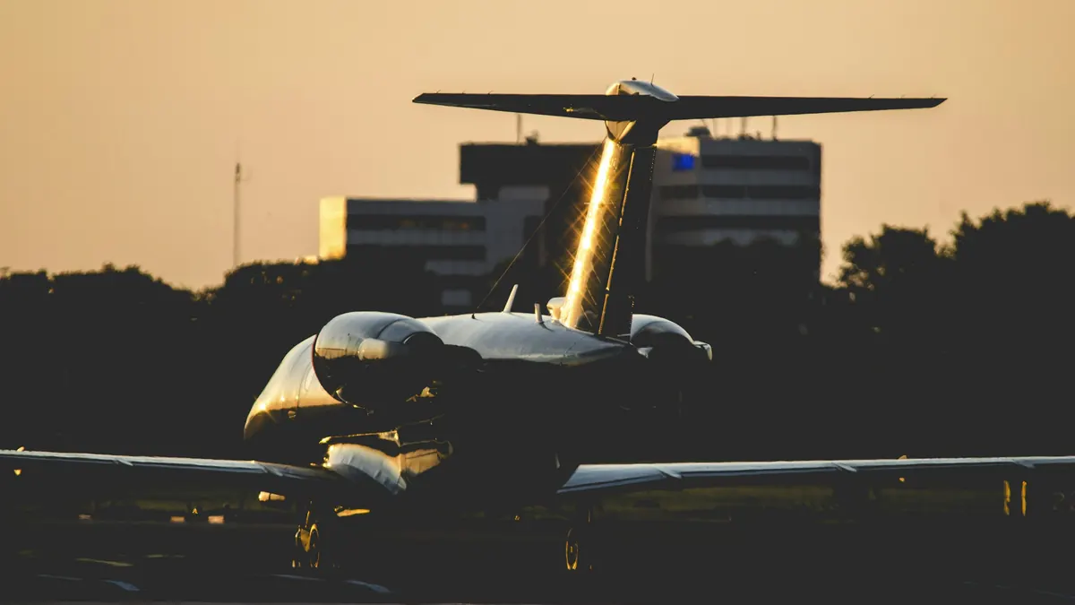 Business jet lit on a dark ramp at night