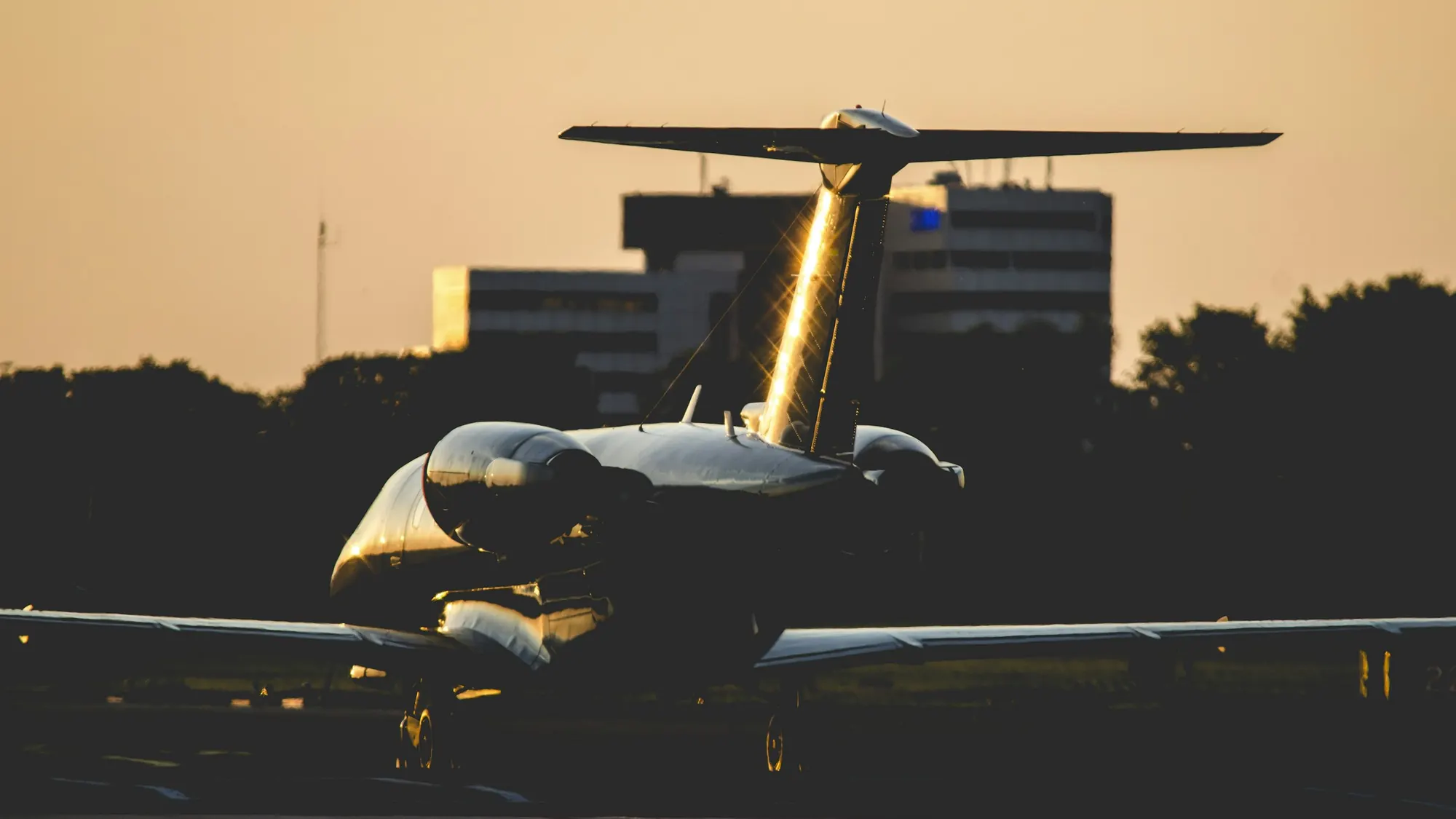 Business jet lit on a dark ramp at night