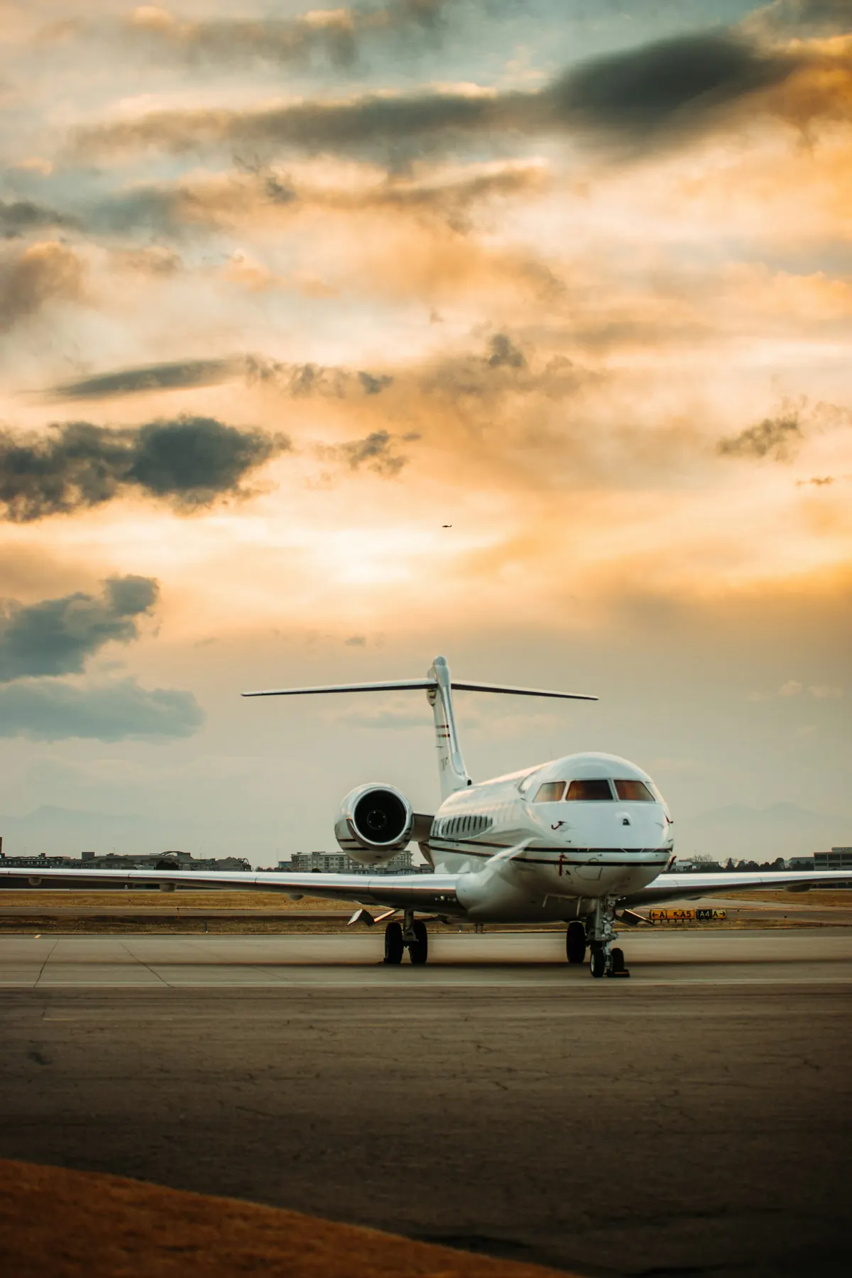 Business jet on the ramp under a gold and violet sunset